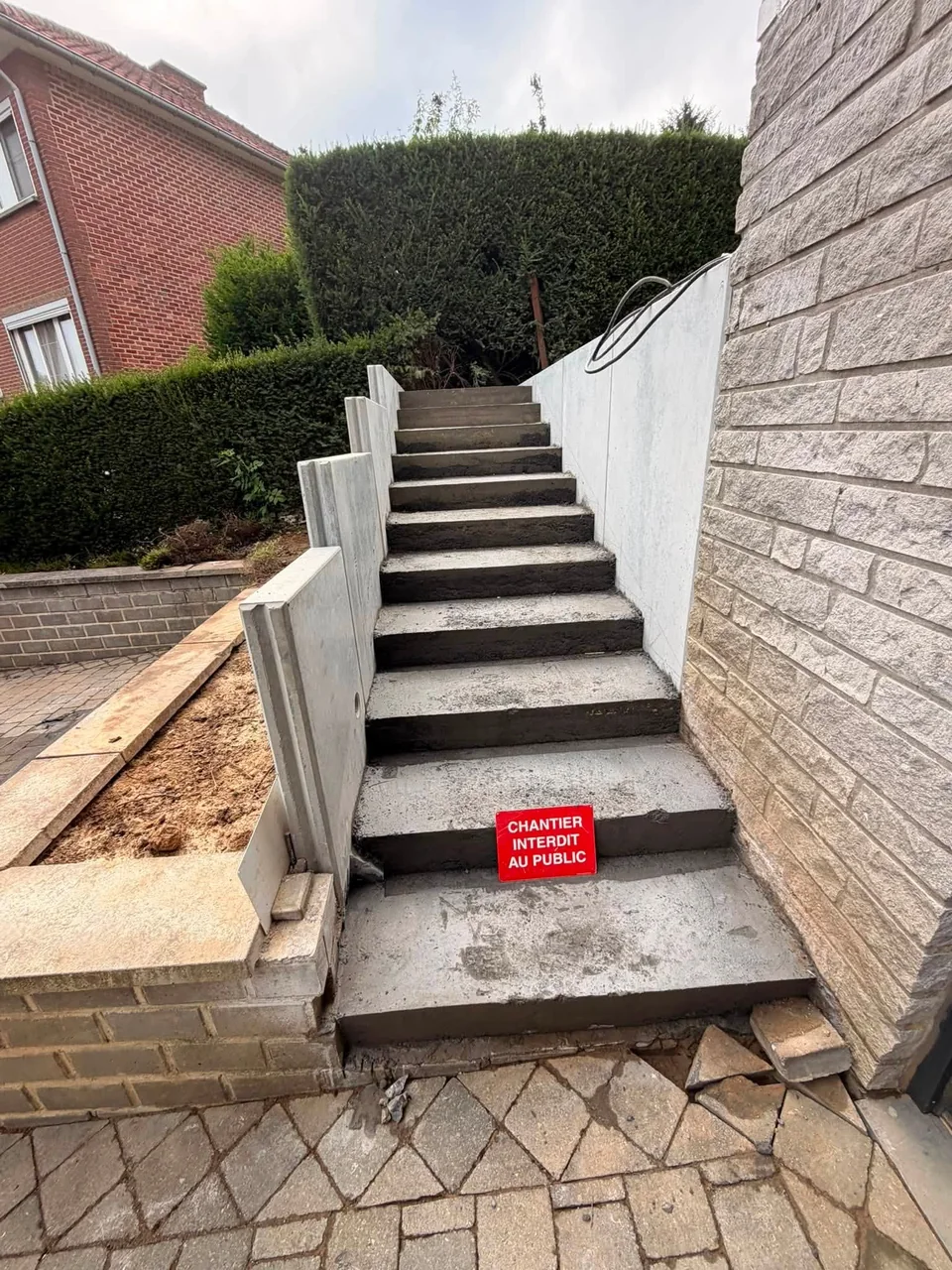 Escalier extérieur entre des murs, avec un garde-corps clair