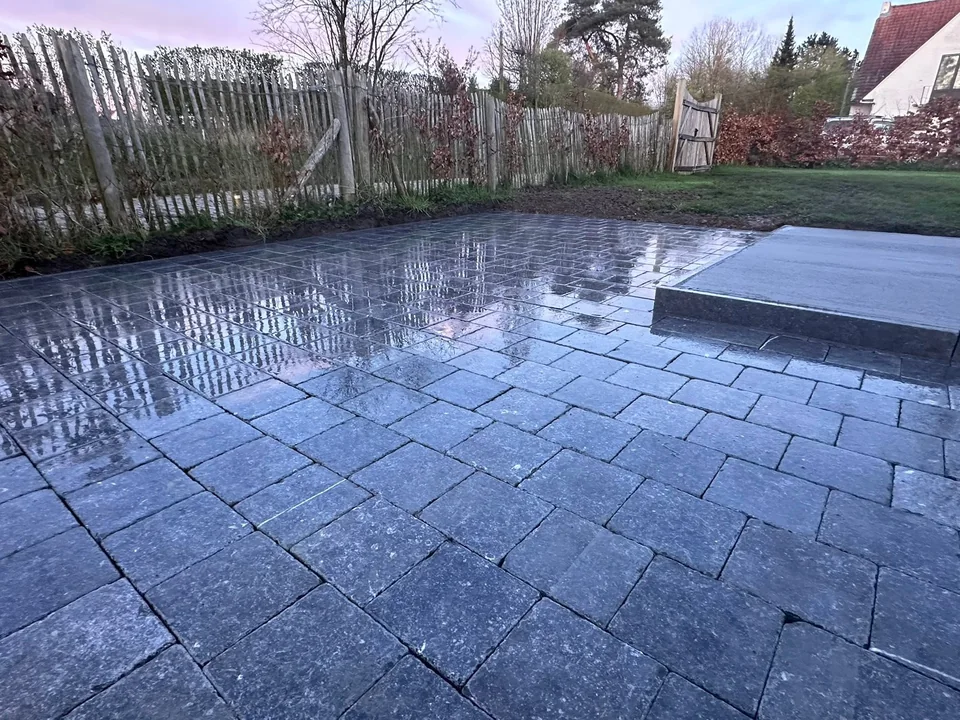 Terrasse en grandes dalles grises avec une marche d’accès